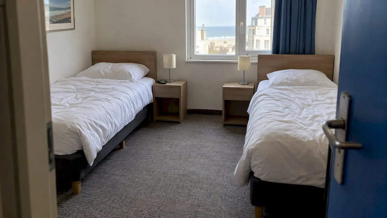 Twee losse bedden in een hotelkamer